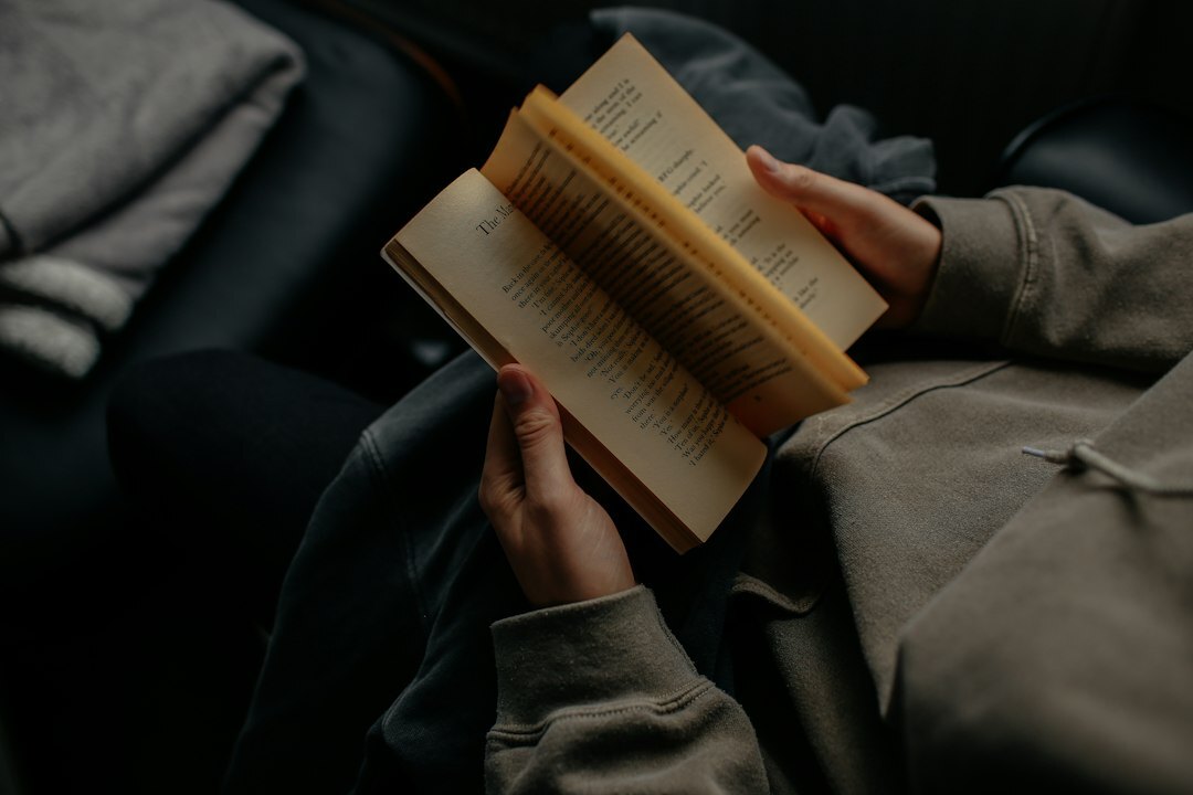 person reading book in dim light